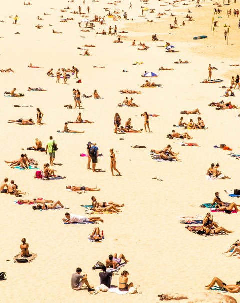 A beach with a lot of people enjoying the sun